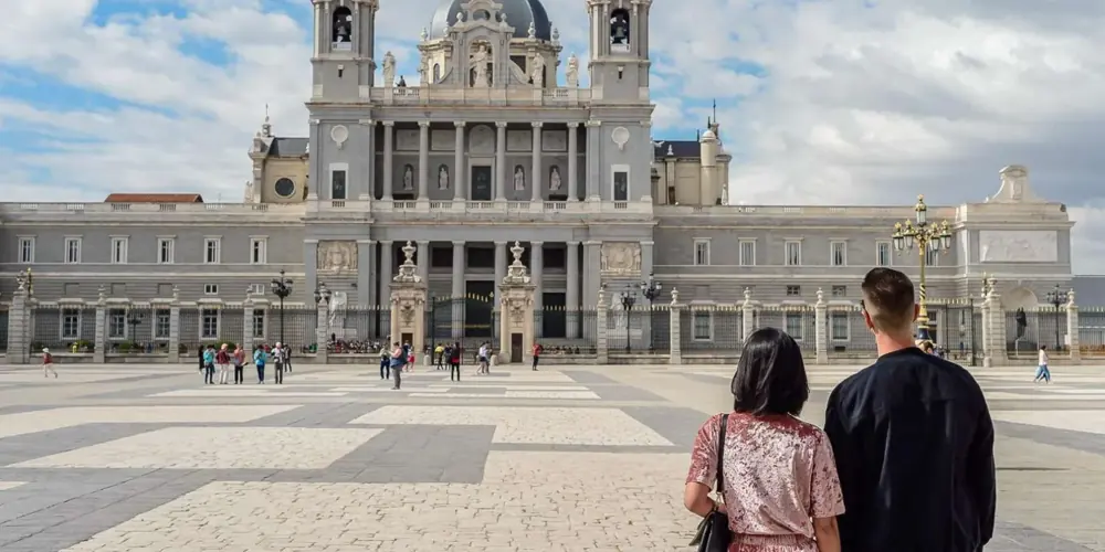 Visitors facing Almudena Cathedral by the palace courtyard