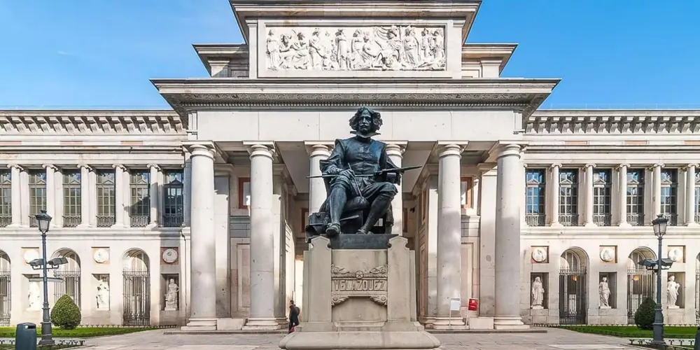 Prado Museum façade behind the statue of Velázquez