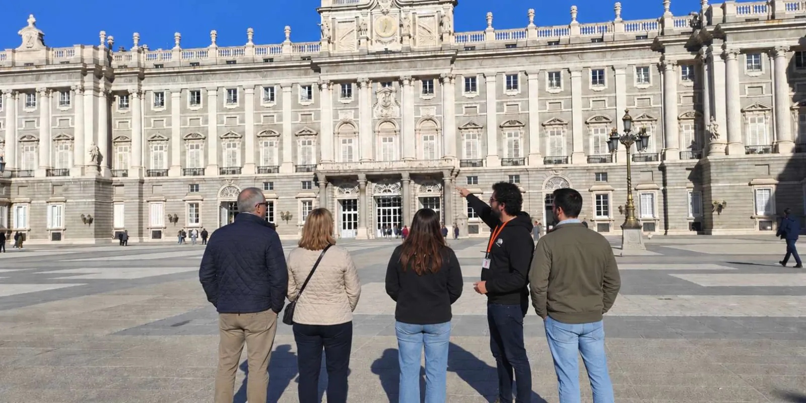 A small group outside the palace façade