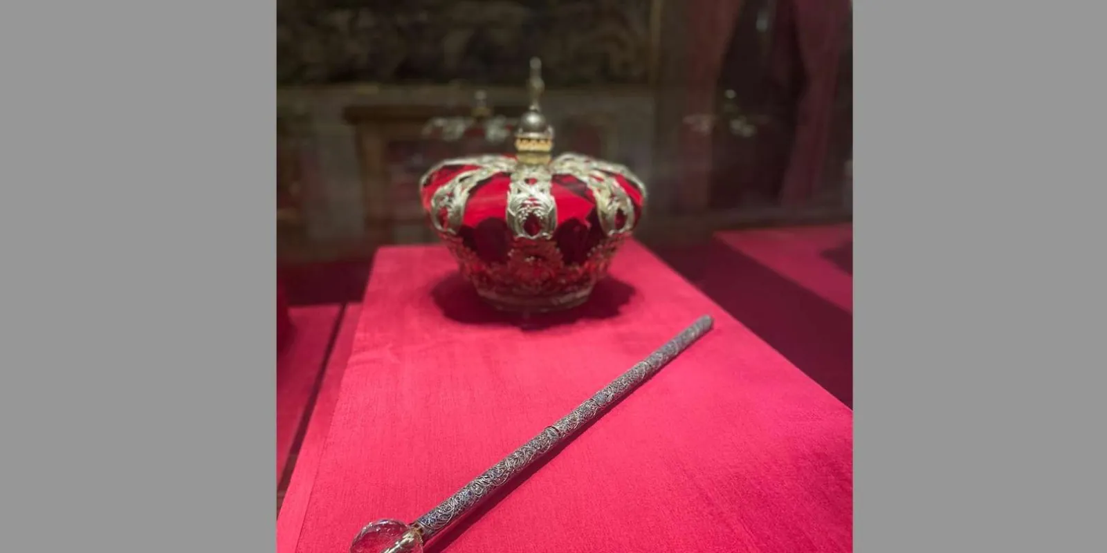 Crown and sceptre displayed on red fabric