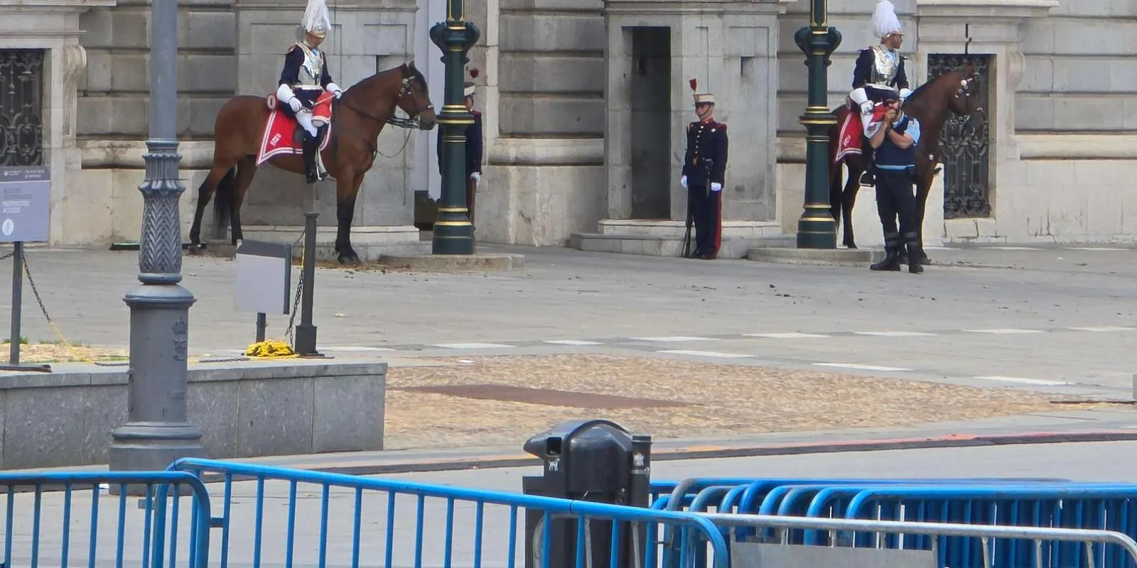 People near a controlled entrance outside the palace